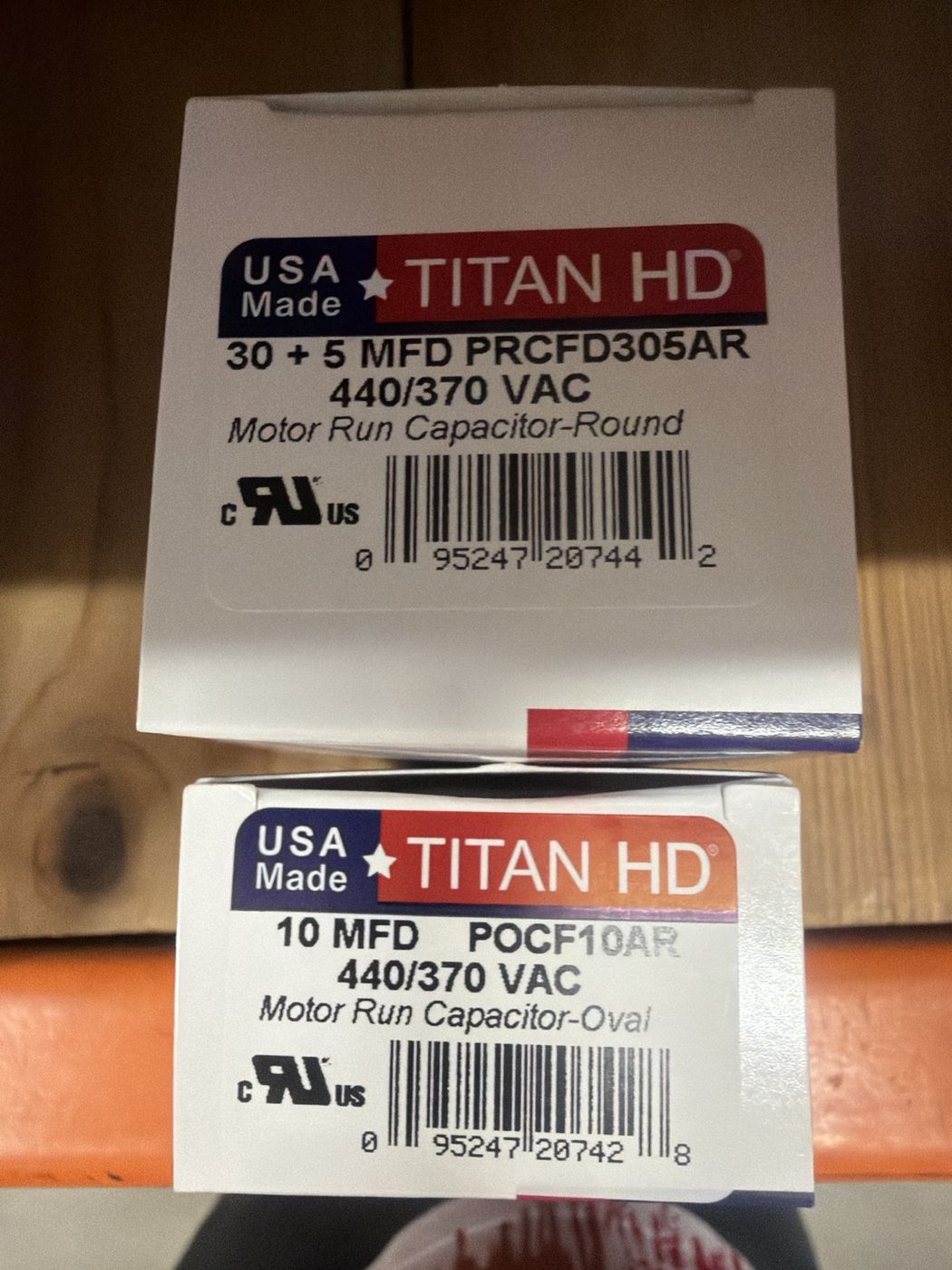 A 30 plus 5 dual run capacitor and a 10 MFD capacitor sitting on the store shelf