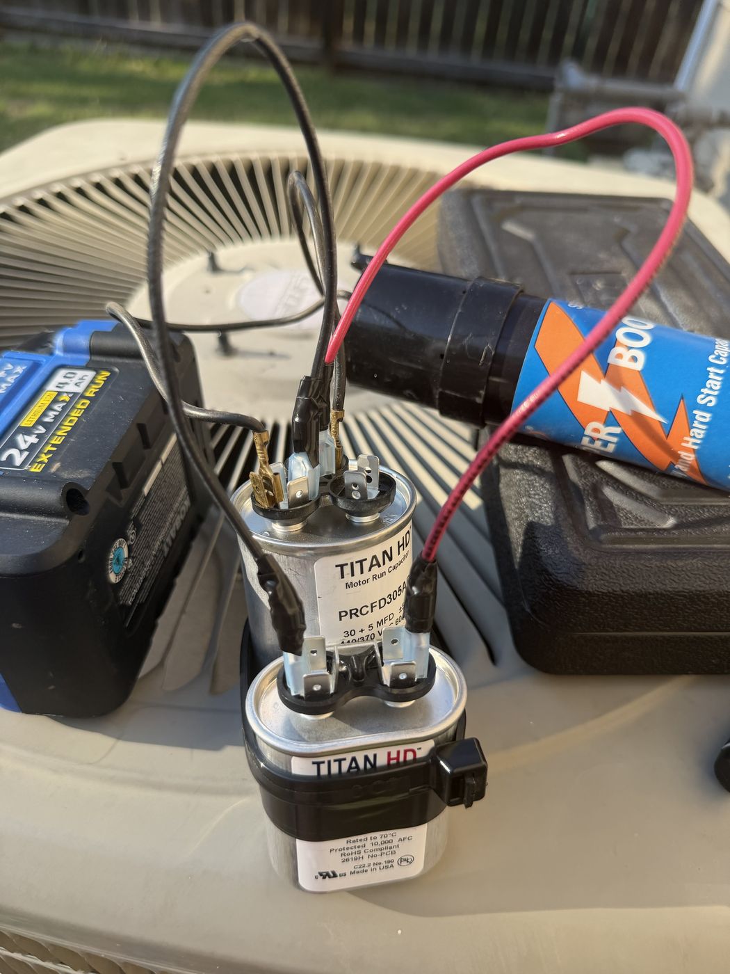 The complete build laid out: the 30 plus 5 capacitor, the 10 MFD capacitor, and short lengths of red and black wire